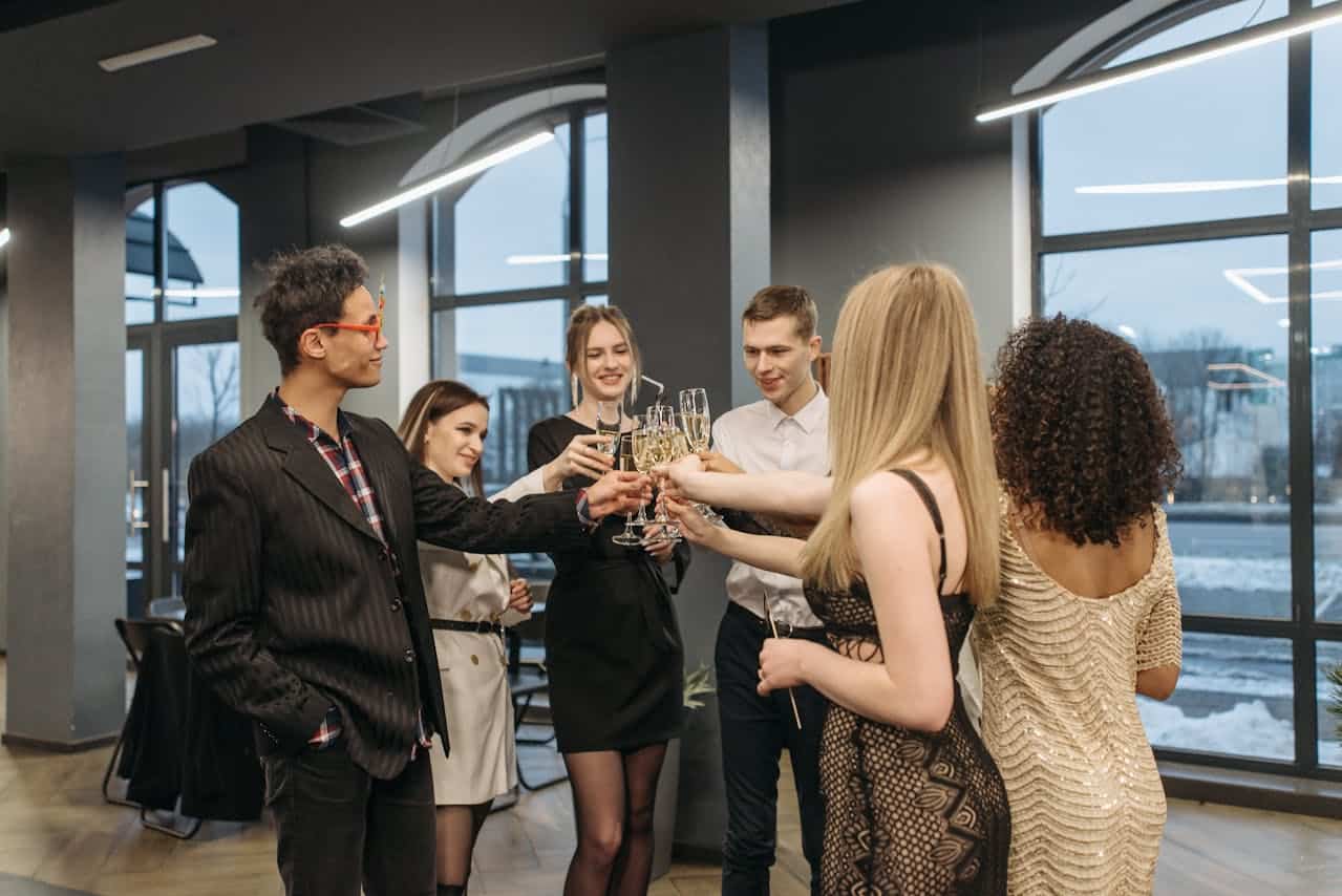 Corporate Celebration at Prime Time Event Planning Group of diverse young professionals celebrating with champagne in modern venue.