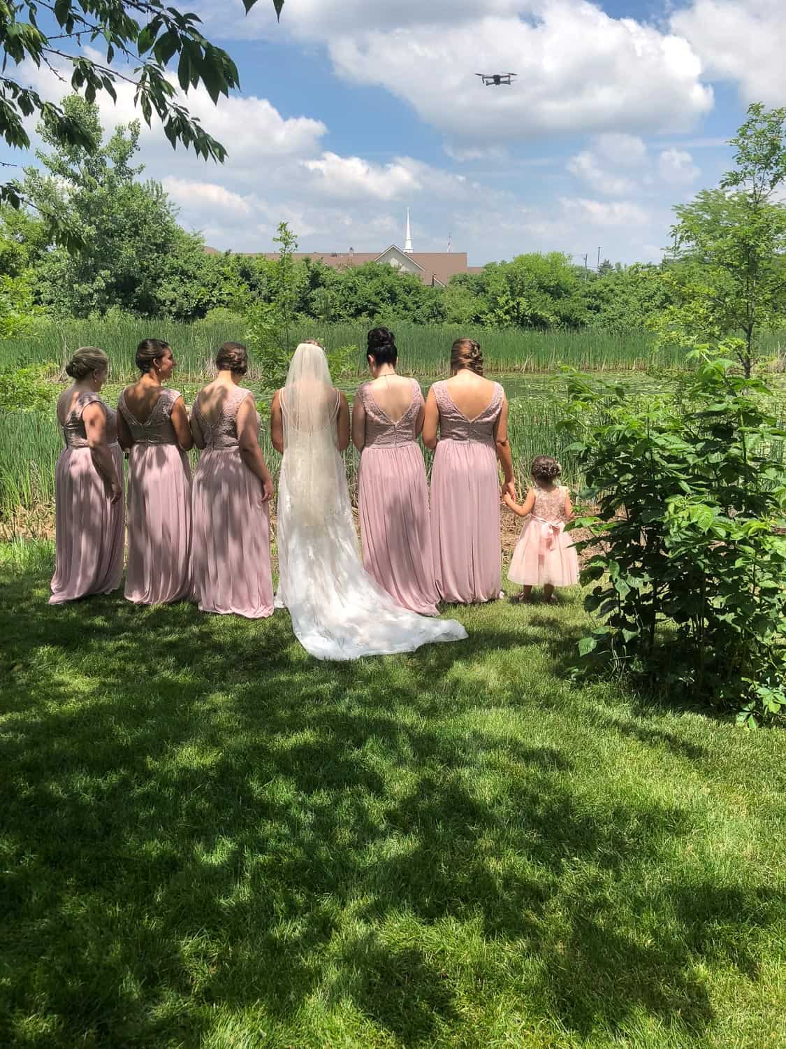 Bridesmaids and bride in pink dresses at outdoor wedding ceremony.