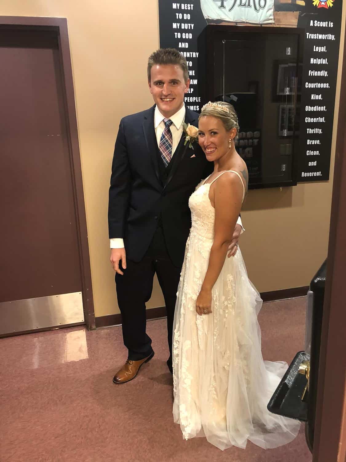 Happy bride and groom at wedding event, smiling and dressed elegantly.
