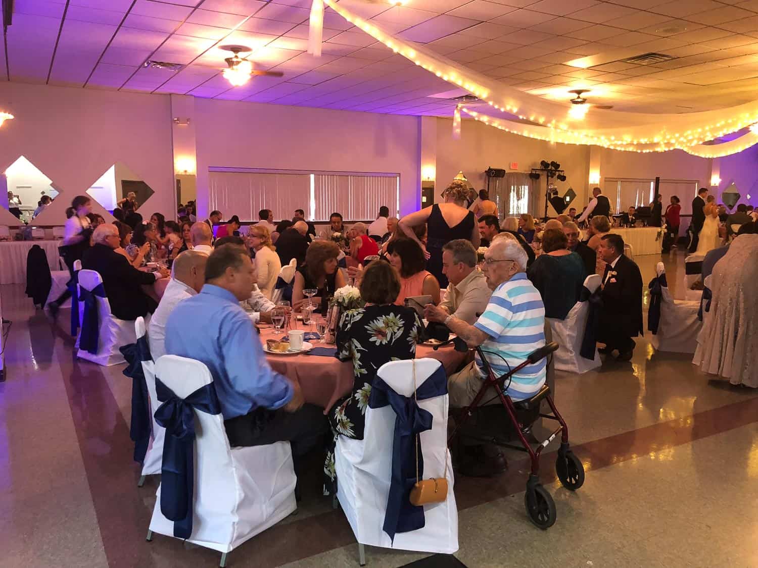 Guests enjoying a formal event with decorated tables and lighting.